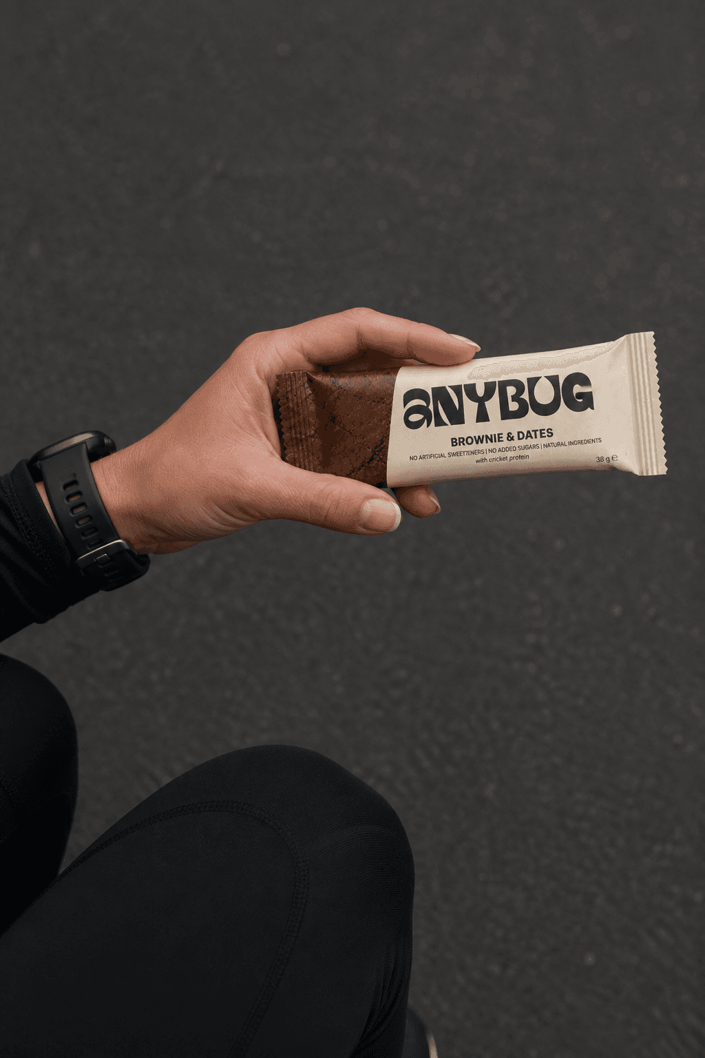 Mano sujetando una barrita AnyBug Brownie & Dates tras salir a correr